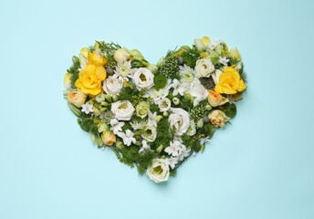Beautiful heart shaped floral composition on turquoise background, flat lay