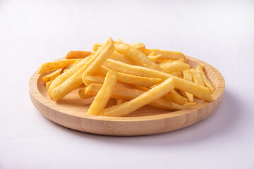 French fries placed on a round wooden plate, white background, selective focus.