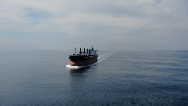 Large cargo ship. A bulk carrier carries cargo across the ocean. Transportation. Delivery. Logistics. A large ship for transporting. Aerial 4k shot.