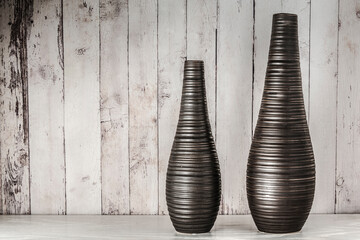 Two brown vases of different sizes against a wooden wall. Concept art. Copy space
