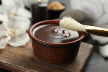 Cosmetic product for spa body wraps on black background, closeup