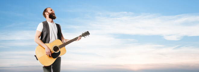 Singer and guitar player singing at sunset