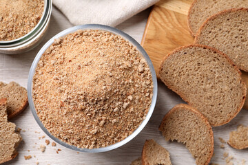 Fresh breadcrumbs on white wooden table, flat lay