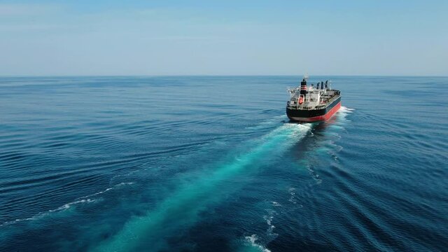 Large cargo ship. A bulk carrier carries cargo across the ocean. Transportation. Delivery. Logistics. A large ship for transporting. Aerial 4k shot.