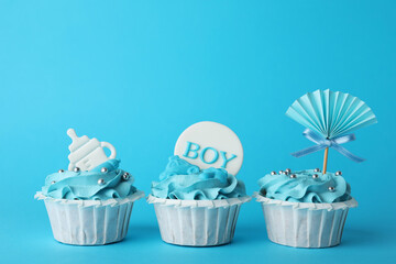 Baby shower cupcakes with toppers on light blue background