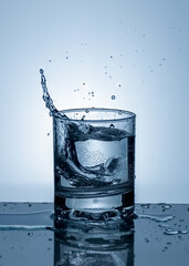 Splash of water in a glass. Splashing water. Ice water. Concept. High quality photo