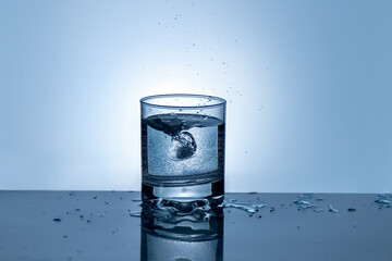 Splash of water in a glass. Splashing water. Ice water. Concept. High quality photo