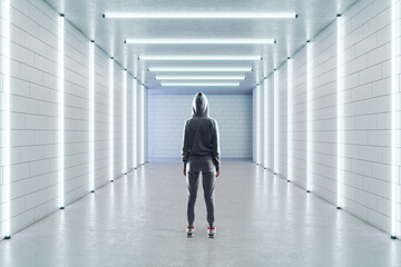 Empty long white gallery with a person standing in the middle, fluorescent lights and a blank white wall in the background, concrete floor and brick walls, interior design and showroom