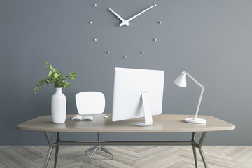 Modern computer, white vase with green plant, lamp on stylish wooden table on grey wall background with clock