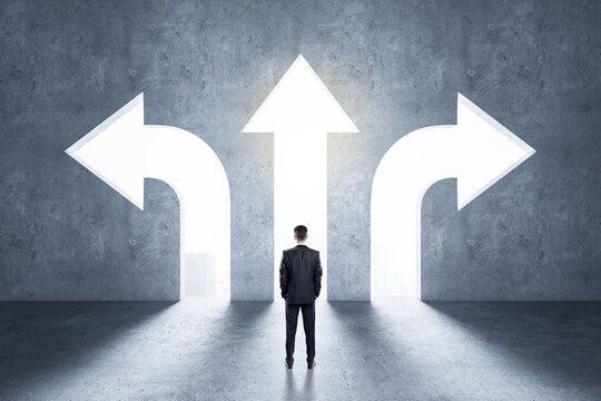 Choice concept with businessman in front of arrow holes directed in different directions in wall