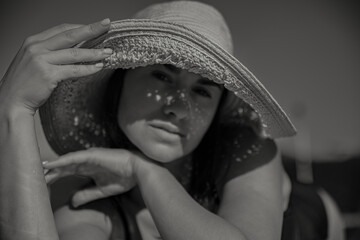 Close up of an attractive girl in a straw hat on a sunny day.