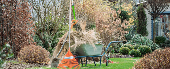 Praca na wiosnę w ogrodzie . Grabienie i sprzątanie ogrodu - obrazy, fototapety, plakaty