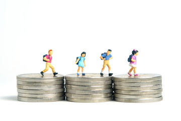 School admission budget.  Children or kids, walking above golden coin money stack. Miniature tiny...