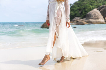 Plakat beautiful girl in a white dress walks along the beach