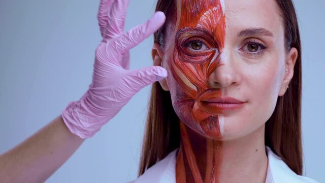 Cosmetic injection in the face. Young woman with half of face with muscles structure under skin. Model for medical training on a light background. Close up video of face human anantomy.