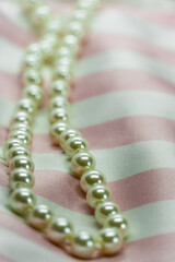 pearl necklace on soft pink satin white striped fabric