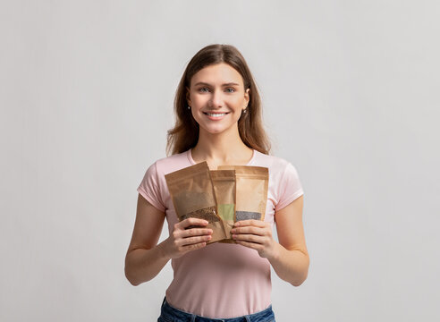 Eco Storage Concept. Smiling Millennial Lady Holding Doypack Bags With Weight Groceries