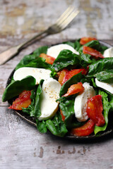 A la caprese salad with spinach, mozzarella and orange. Healthy food. Diet concept. Beautiful and delicious salads.