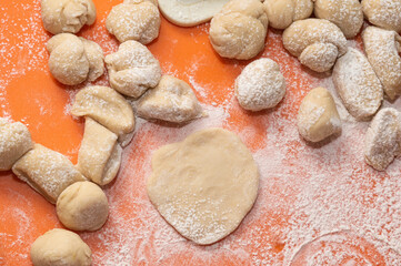 Fototapeta na wymiar pieces of raw dough on an orange surface