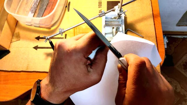 Cutting paper with a sharp knife. Close-up, male hands.Video