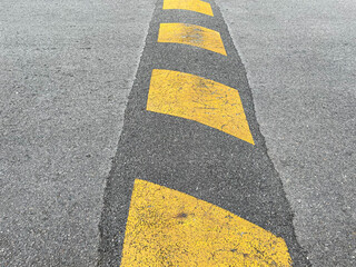 Vertical striped black and yellow asphalt speed hump and bump.