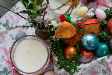 Fototapeta na wymiar Wielkanocny baranek z baziami, perłowe jaja wielkanocne, wielkanocny koszyk, stół 