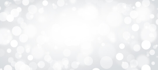 Defocused white lights on a gray background. Abstract bokeh on a white background.