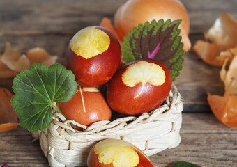 Easter eggs with onion peel in a natural basket on an ancient wooden background.Easter background.