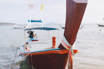 Traditional Thai wooden longtail boat close up photo. Bow of Long Tail Boat with beautiful color. Fishing boat bow on sky and sea beach background with copy space. Holiday concept
