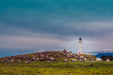 Fototapeta na wymiar Retro-style photo of Cape Egmont Lighthouse. Gloomy winter day in Taranaki, New Zealand