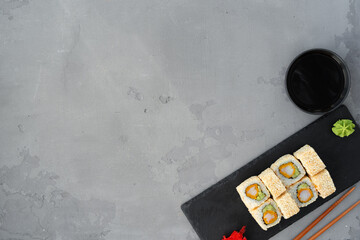 Naklejka premium Sushi roll with sesame served on gray table