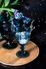 Ice cubes splashing into glass of water