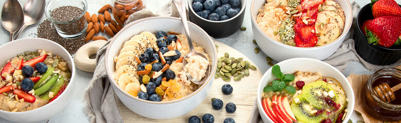 Oatmeal bowls with delicious fruits and fresh berries on light background.
