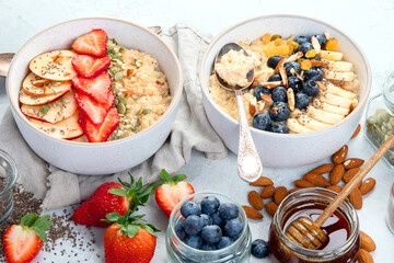 Oatmeal bowls with delicious fruits and fresh berries on light background.