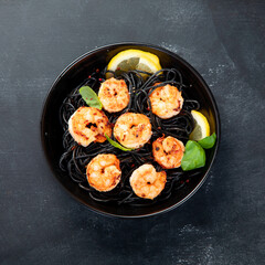 Spaghetti with shrimps and parmesan on dark background. Tasty appetizings seafood pasta.