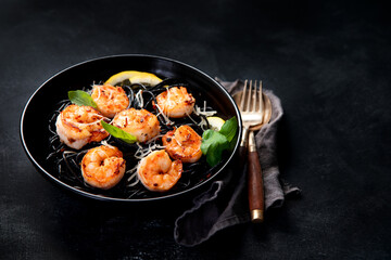 Spaghetti with shrimps and parmesan on dark background. Tasty appetizings seafood pasta.