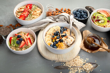 Oatmeal bowls with delicious fruits and fresh berries on light background.