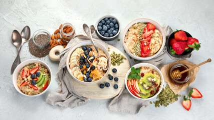 Oatmeal bowls with delicious fruits and fresh berries on light background.
