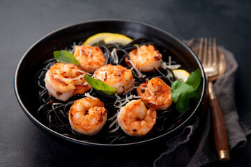 Spaghetti with shrimps and parmesan on dark background. Tasty appetizings seafood pasta.