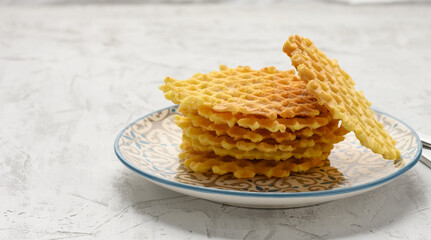 stack of baked Belgian waffles on a round plate on a white table, delicious breakfast