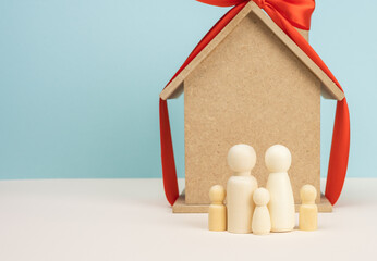 wooden house and miniature family figures, mortgage and loan concept
