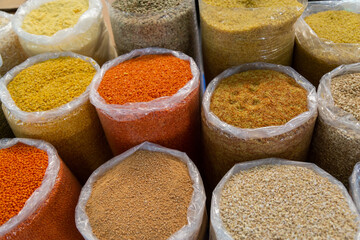Proper healthy nutrition. Variety organic groats in bags for storage on a farmers market, ecological cereal products, lentils, wheat, bulgur, millet. Natural organic background