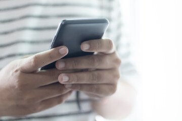 Hands holding and using smartphone.