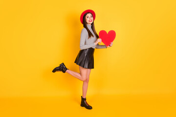 Fototapeta na wymiar Full body photo of nice cute sweet young woman hold red heart figure good mood smile isolated on yellow color background
