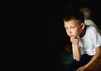 emotional, cheerful portrait of a boy on a dark background, posto per il testo, ragazzo serio, selective focus