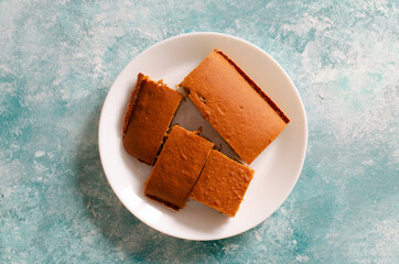 pieces of biscuit on white plate on abstract aqua background. Beautiful texture.