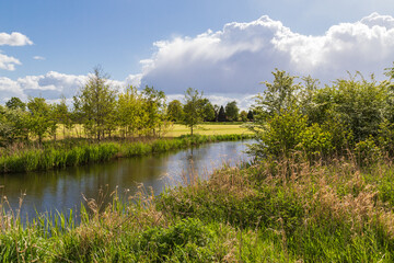Fototapeta na wymiar View of the river Barneveldse Beek in the Dutch polder landscape.