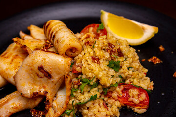 Squid with a side dish of bulgur and dried tomatoes.