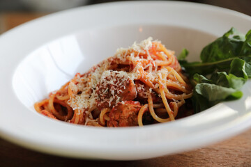 spaghetti Bolognese with italian sausage and tomato sauce with parmesan cheese and basil