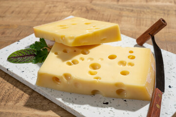 Cheese collection, blocks of French emmentaler cheese with many round holes made from cow milk